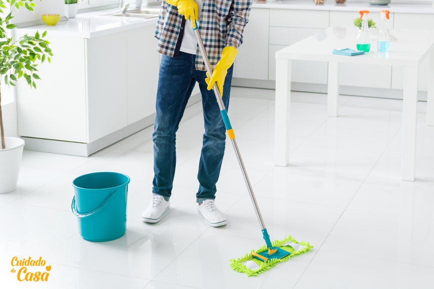 Homem com limpador de piso fazendo a higienização da cozinha