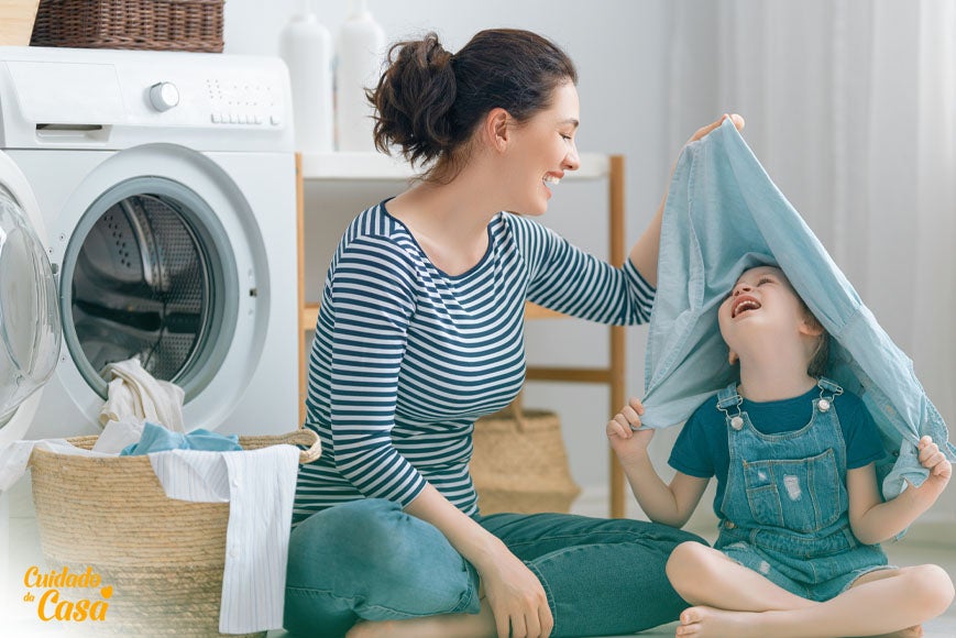 Mãe brincando com o filho na hora de lavar roupa na máquina