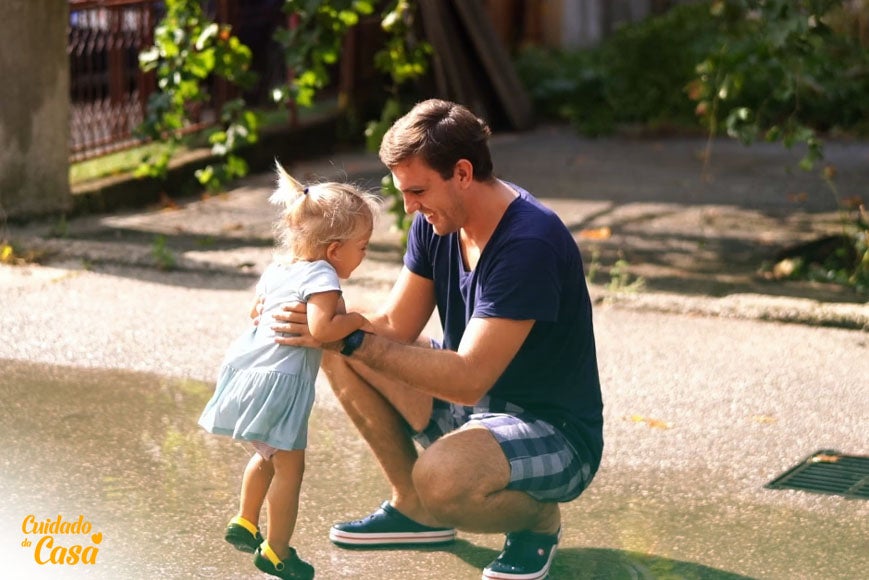 Pai brincando com a filha após seguir dicas de como tirar todo lodo do quintal