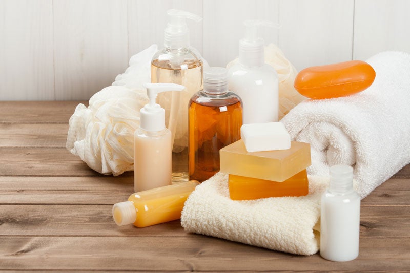 Kit de amenidades com sabonete líquido, em barra, condicionador, shampoo, toalhas e touca de banho para rebeber visita em casa.