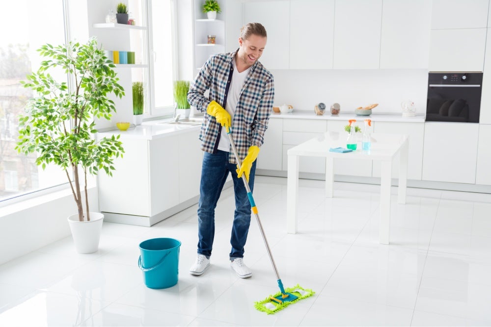 Homem fazendo faxina usando um limpador de chão eficiente