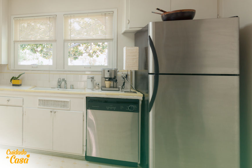 Imagem de uma cozinha com bancada, pia, lava-louças inox e geladeira inox