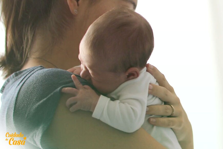 Mãe segurando o recém-nascido  no colo e pensando qual o melhor sabão para lavar roupa de bebê recém-nascido